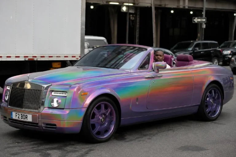 50 Cent's Rolls-Royce Phantom Drophead Coupe with custom rainbow oil-slick paint showcased during filming of Entourage in 2009 and later seen in a unique gray hood purple-blue body configuration photographed in New York City in 2017 originally purchased for approximately 750000 dollars in 2007 a figure equivalent to approximately 1.1 million dollars adjusted for inflation described by DJ Envy who maintains 50 Cent's Rolls-Royce vehicles as probably 50 Cent's second-favorite car in the collection powered by a 6.75 liter V12 in the nearly 6000 pound convertible body