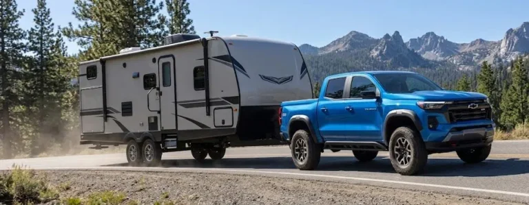 2026 Chevrolet Colorado towing a boat or large trailer showing the class-leading 7700-pound maximum towing capacity available on the WT LT Trail Boss and Z71 trims with the 2.7-liter TurboMax 430 lb-ft of torque providing the low-RPM pulling force needed for boat ramps hill climbs and highway merging with a heavy trailer attached while the integrated trailer brake controller on the Trail Boss coordinates braking between truck and trailer