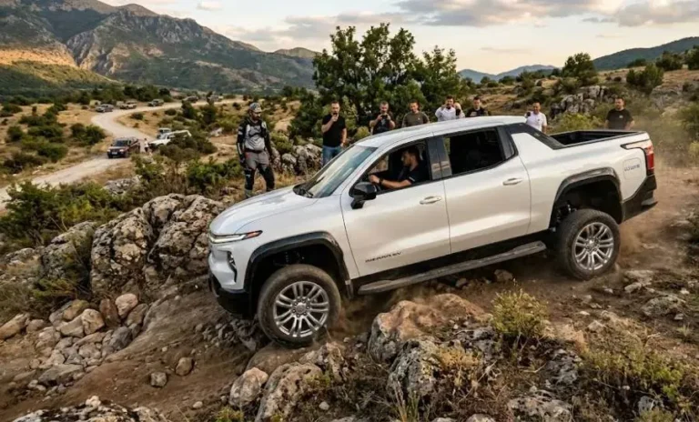 2026 GMC Sierra EV demonstrating CrabWalk four-wheel steering mode that allows the truck to move diagonally alongside Super Cruise hands-free highway driving system and a 16.8-inch infotainment screen in the Denali trim with 760 horsepower 785 lb-ft torque 12500 pound maximum towing and similar range capabilities to the Chevrolet Silverado EV on the same Ultium platform but with premium interior and technology additions